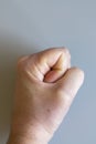 fist on gray background. The concept of domestic violence. Male rudeness and violence. vertical photo