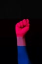 Fist hand with bisexual pride flag patterned isolate on black. LGBTQ+ rights concept