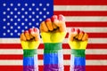 Fist hand with rainbow flag patterned on flag of United states o