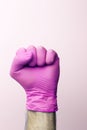A fist in a medical glove. Doctor`s hand in a pink medical glove on a light background Royalty Free Stock Photo