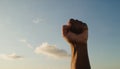 Fist raised up against the background of the sunset sky.