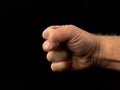 Fist ready for battle, on a black background. Fingers tightly clenched. The strong man raised his fist. Concept: aggression, power Royalty Free Stock Photo