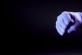 Fist of right man hand in a purple medical glove on a black background