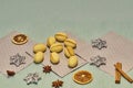 Fistful of walnut shaped butter cookies on grey napkins, cinnamon sticks, slices of dried orange and apple, Christmas spices Royalty Free Stock Photo