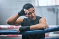 Fit, active or healthy boxing man feeling tired, hot and wiping sweat after workout, training or exercise in ring Royalty Free Stock Photo