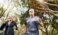 Fit, active and healthy mature couple jogging, running and enjoying their fitness lifestyle outside in nature during Royalty Free Stock Photo