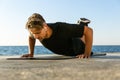 fit adult man with wireless earphones doing push ups on knees Royalty Free Stock Photo