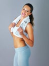 Fit as a fiddle. Cropped portrait of an attractive and sporty young woman holding a water bottle against a grey Royalty Free Stock Photo