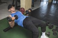 A fit asian man in a blue tank top does lying dumbbell curl on a bench. Challenging bicep isolation exercise and workout Royalty Free Stock Photo