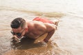 A fit asian man wearing shades does pushups at the beach. Chest workout or calisthenics outdoors Royalty Free Stock Photo