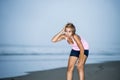 Fit Asian sport runner woman cooling off breathing after running on beach sea side looking tired while hard workout Royalty Free Stock Photo