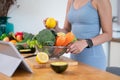 A fit Asian woman in gym clothes is preparing ingredients for her healthy breakfast in the kitchen Royalty Free Stock Photo