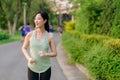 Fit Asian young woman jogging in park smiling happy running and enjoying a healthy outdoor lifestyle. Female jogger. Fitness Royalty Free Stock Photo