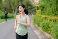 Fit Asian young woman jogging in park smiling happy running and enjoying a healthy outdoor lifestyle. Female jogger. Fitness Royalty Free Stock Photo