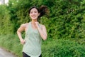 Fit Asian young woman jogging in park smiling happy running and enjoying a healthy outdoor lifestyle. Female jogger. Fitness Royalty Free Stock Photo