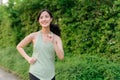 Fit Asian young woman jogging in park smiling happy running and enjoying a healthy outdoor lifestyle. Female jogger. Fitness Royalty Free Stock Photo