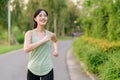 Fit Asian young woman jogging in park smiling happy running and enjoying a healthy outdoor lifestyle. Female jogger. Fitness Royalty Free Stock Photo