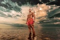 Fit athlete bodybuilder in the sea. Attractive young man lifeguard.