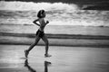 Fit and athletic Asian Chinese sporty woman running on beautiful beach doing jogging workout on sunset in fitness healthy lifestyl Royalty Free Stock Photo