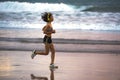 Fit and athletic Asian Chinese sporty woman running on beautiful beach doing jogging workout on sunset in fitness healthy lifestyl Royalty Free Stock Photo