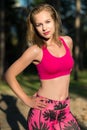 Fit athletic woman standing in a forest, sweating and taking a break from intense workout Royalty Free Stock Photo