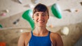 Fit Beautiful Female Athlete Smiling and Posing at Rock Climbing Gym with Bouldering Wall Background Royalty Free Stock Photo