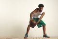 Fit black athlete playing with a vintage basketball