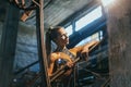 fit blonde woman standing in factory setting Royalty Free Stock Photo