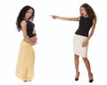 A fit business woman in a skirt points with shock at a pregnant