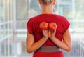 Fit business woman with tomatoes as a healhy snack - back view