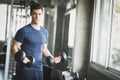 Fit caucasian handsome young man and big muscle in sportswear. Young man holding dumbbell during an exercise class in a gym