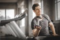 Fit caucasian handsome young man and big muscle in sportswear. Young man holding dumbbell during an exercise class in a gym