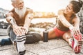 Fit couple making stretching before running workout - Joggers training outdoor at sunset together - Main focus on womaman face -