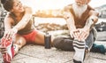 Fit couple making stretching before running workout - Joggers training outdoor at sunset together - Main focus on woman face -