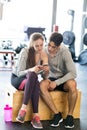 Fit couple in modern crossfit gym with smartphone. Royalty Free Stock Photo