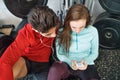 Fit couple in modern crossfit gym with smartphone. Royalty Free Stock Photo