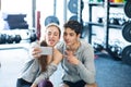 Fit couple in modern crossfit gym with smartphone. Royalty Free Stock Photo