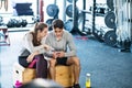 Fit couple in modern crossfit gym with smartphone. Royalty Free Stock Photo