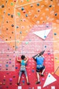 Fit couple rock climbing indoors