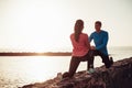 Fit couple stretching and training legs outdoor - Sporty young people doing workout session exercises next the beach Royalty Free Stock Photo