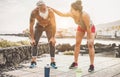 Fit couple taking a rest after fast running workout - Joggers training outdoor at sunset together - Focus on faces - Fitness,