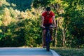 Fit cyclist rides his bicycle bike on an empty road in nature Royalty Free Stock Photo