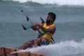 Fit dark-skinned male kite surfing on the water near Kudawa beach, Sri Lanka