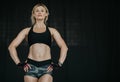 Fit female model with perfect torso in studio. Middle age woman in sportswear, with smart watch and gloves