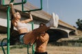 Friends Enjoying a Sunny Day Workout in the Park, Pull-Ups and Stretching on Horizontal Metal Bars