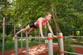 Fit girl doing exercise push ups on sports bars outdoor Royalty Free Stock Photo