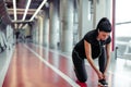 Girl down to do shoelaces at fitness gym before running exercise workout Royalty Free Stock Photo