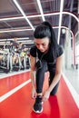 Girl down to do shoelaces at fitness gym before running exercise workout Royalty Free Stock Photo