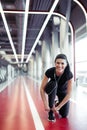 Fit girl down to do shoelaces at fitness gym before running exercise workout Royalty Free Stock Photo