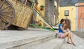 Fit girl in flips flops sitting in stairs of a main square with folk decoration from a traditional party in Canary Islands,